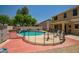 Beautiful backyard pool with patio seating, surrounded by a safety fence and lush landscaping at 17766 W Caribbean Ln, Surprise, AZ 85388