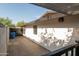 A shaded back patio features sleek dark trim, with a wall of windows and a concrete privacy fence for relaxation and security at 1861 W Navarro Ave, Mesa, AZ 85202