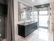 Stylish bathroom showcasing a floating dual vanity with sleek black cabinets and a glass-enclosed walk-in shower at 1861 W Navarro Ave, Mesa, AZ 85202
