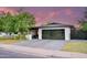 Inviting single-story house with modern garage door under dusk skies, surrounded by lush greenery at 1861 W Navarro Ave, Mesa, AZ 85202