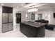Open kitchen featuring a large center island with seating, modern appliances, and marble flooring at 1861 W Navarro Ave, Mesa, AZ 85202