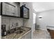 Stylish bar area with a granite countertop, sink, beverage cooler and gray subway tile backsplash at 18865 W Mescal St, Surprise, AZ 85388