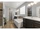 Bright bathroom with wood-look tile floors, dual sinks, soaking tub, and plenty of counter space at 18865 W Mescal St, Surprise, AZ 85388