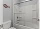 This full bathroom features a shower-tub combo with modern sliding glass doors, and nice fixtures at 18865 W Mescal St, Surprise, AZ 85388