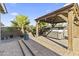 Backyard patio with a covered hot tub, palm trees, and steps leading up to the area at 18865 W Mescal St, Surprise, AZ 85388