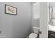 Clean powder room featuring wood-look tile, updated fixtures, and a decorative picture at 18865 W Mescal St, Surprise, AZ 85388