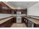 Functional kitchen featuring wood cabinets, white appliances, and tile flooring at 19700 N 76Th St # 1103, Scottsdale, AZ 85255