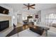 Bright living room featuring a fireplace, ceiling fan, and open layout to the kitchen and dining area at 19700 N 76Th St # 2057, Scottsdale, AZ 85255