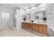 Bright bathroom with a glass enclosed shower, double sinks and wood cabinets at 1991 W Bartlett Ct, Chandler, AZ 85248