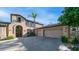 Inviting two-story home with lush landscaping, an arched entryway, and a convenient three-car garage for ample parking and storage at 1991 W Bartlett Ct, Chandler, AZ 85248