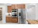 Stainless steel refrigerator and oven are surrounded by custom wood cabinets in the kitchen at 1991 W Bartlett Ct, Chandler, AZ 85248