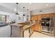 Modern kitchen features wooden cabinets, stainless appliances, and open breakfast bar with pendant lighting at 20100 N 78Th Pl # 2193, Scottsdale, AZ 85255