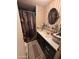 Bathroom with single sink vanity, oval mirror, and unique shower curtain at 20644 N 36Th Ave, Glendale, AZ 85308