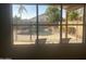 Enjoy a backyard oasis with pool, waterfall feature and desert landscaping, viewed through a large window at 2092 E Smoke Tree Rd, Gilbert, AZ 85296
