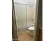 Compact bathroom shows neutral colors, tile floor, a glass-enclosed shower over tub, and standard toilet at 2092 E Smoke Tree Rd, Gilbert, AZ 85296