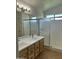 Well-lit bathroom features a dual sink vanity and a glass enclosed shower, all on a tile floor at 2092 E Smoke Tree Rd, Gilbert, AZ 85296