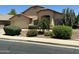 Charming single-story home featuring a well-manicured front yard with desert landscaping and a two-car garage at 2092 E Smoke Tree Rd, Gilbert, AZ 85296