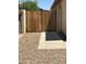Wooden gate surrounded by gravel and flowering shrubs offering privacy and an inviting touch at 2092 E Smoke Tree Rd, Gilbert, AZ 85296