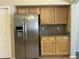 Kitchen detail showing the stainless steel refrigerator and natural wood cabinets with granite countertop at 2092 E Smoke Tree Rd, Gilbert, AZ 85296