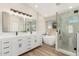 Bright bathroom showcasing a double vanity, soaking tub, and glass-enclosed shower with stylish tile work at 20961 N 96Th Dr, Peoria, AZ 85382