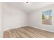 Bright bedroom with wood floors and a window overlooking the backyard at 20961 N 96Th Dr, Peoria, AZ 85382