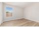 Simple bedroom with wood floors, a window, and light-colored walls at 20961 N 96Th Dr, Peoria, AZ 85382