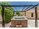 Backyard hot tub with wooden paneling and overhead pergola provides an outdoor relaxation space at 20961 N 96Th Dr, Peoria, AZ 85382