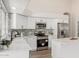 Modern kitchen with white cabinets, stainless steel appliances, granite countertops, and a gray tile backsplash at 20961 N 96Th Dr, Peoria, AZ 85382