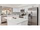 Bright kitchen featuring white cabinets, stainless steel appliances, a large island, and stylish countertops and backsplash at 20961 N 96Th Dr, Peoria, AZ 85382