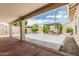 Covered patio featuring a seating area and spa, surrounded by lush landscaping at 20961 N 96Th Dr, Peoria, AZ 85382