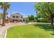 Expansive backyard oasis with pool, lush lawn, patio, and mature trees creating a relaxing retreat at 2438 S Chestnut Pl, Chandler, AZ 85286