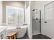 Bright bathroom featuring a freestanding tub, walk-in shower, and plantation shutters at 2438 S Chestnut Pl, Chandler, AZ 85286