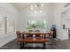 Bright dining room featuring modern lighting, a wooden table with bench, and large window at 2438 S Chestnut Pl, Chandler, AZ 85286