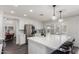 Modern kitchen with white cabinets, stainless steel appliances, a large island, and adjacent dining area at 2438 S Chestnut Pl, Chandler, AZ 85286