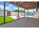 View from covered patio to the swimming pool in the backyard and grass at 2801 E Sunnyside Dr, Phoenix, AZ 85028