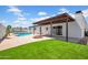 Large backyard featuring a covered patio, pool, fire pit, and grass area at 2801 E Sunnyside Dr, Phoenix, AZ 85028