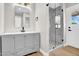 Bright bathroom with gray vanity, undermount sinks, and glass enclosed shower with decorative tile floor at 2801 E Sunnyside Dr, Phoenix, AZ 85028