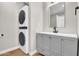 Bathroom with gray vanity and sink adjacent to stackable washer and dryer at 2801 E Sunnyside Dr, Phoenix, AZ 85028