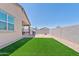 Grassy backyard with covered patio and outdoor kitchen with a grill and fire pit at 2898 E Kim Dr, San Tan Valley, AZ 85143