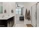 Bathroom with double sinks, dark wood cabinets, and a glass-enclosed shower; bedroom with ceiling fan and window view at 2898 E Kim Dr, San Tan Valley, AZ 85143