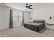 Bright bedroom featuring a modern black metal bed frame, neutral carpet, and ample natural light from a window at 2898 E Kim Dr, San Tan Valley, AZ 85143
