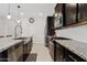 Well-equipped kitchen with dark cabinets, granite countertops, stainless steel appliances, and a subway tile backsplash at 2898 E Kim Dr, San Tan Valley, AZ 85143