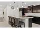 Stylish kitchen featuring dark cabinets, granite countertops, a large island, and stainless steel appliances at 2898 E Kim Dr, San Tan Valley, AZ 85143