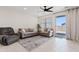 Bright living room with tile floors, neutral sofas, a ceiling fan, and sliding glass doors at 2898 E Kim Dr, San Tan Valley, AZ 85143