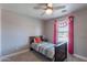 Charming bedroom featuring a bed, ceiling fan, and window adorned with a colorful pennant banner at 3047 S Mandy St, Mesa, AZ 85212