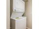 Close-up of a stacked washer and dryer set in a laundry closet with a tile floor at 3324 S Parkside Dr, Tempe, AZ 85282