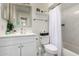 Bright bathroom featuring a single sink vanity, toilet, and shower-tub combo with white marble-style tile surround at 3447 E Dolphin Ave, Mesa, AZ 85204