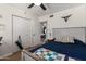 Bedroom features a bed, ceiling fan, closet, yoga mat and office area at 3447 E Dolphin Ave, Mesa, AZ 85204