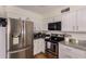 Modern kitchen featuring stainless steel appliances, granite countertops, and white cabinets at 3447 E Dolphin Ave, Mesa, AZ 85204