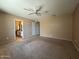 Spacious bedroom with a ceiling fan and neutral carpet, leading to an ensuite bathroom at 3740 E Mercer Ln, Phoenix, AZ 85028